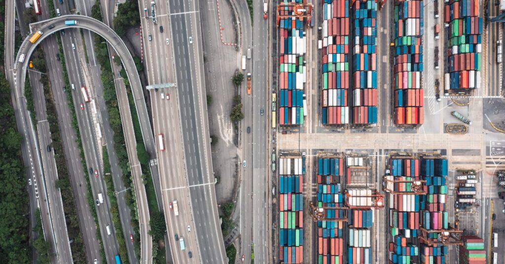 Aerial shot of Hong Kong's shipping containers and highway interchange showcasing urban logistics.