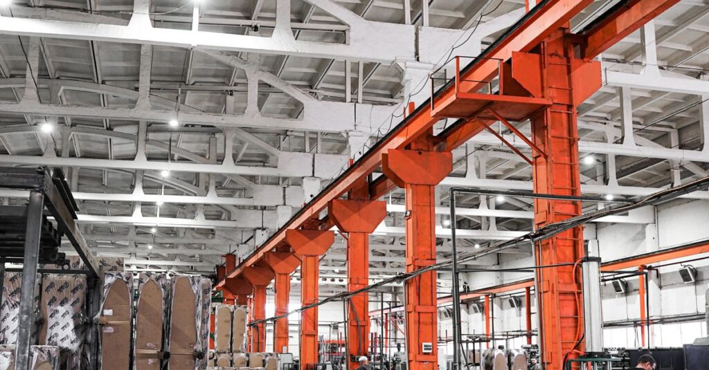Spacious industrial plant interior featuring machinery and metal frames with a high ceiling.