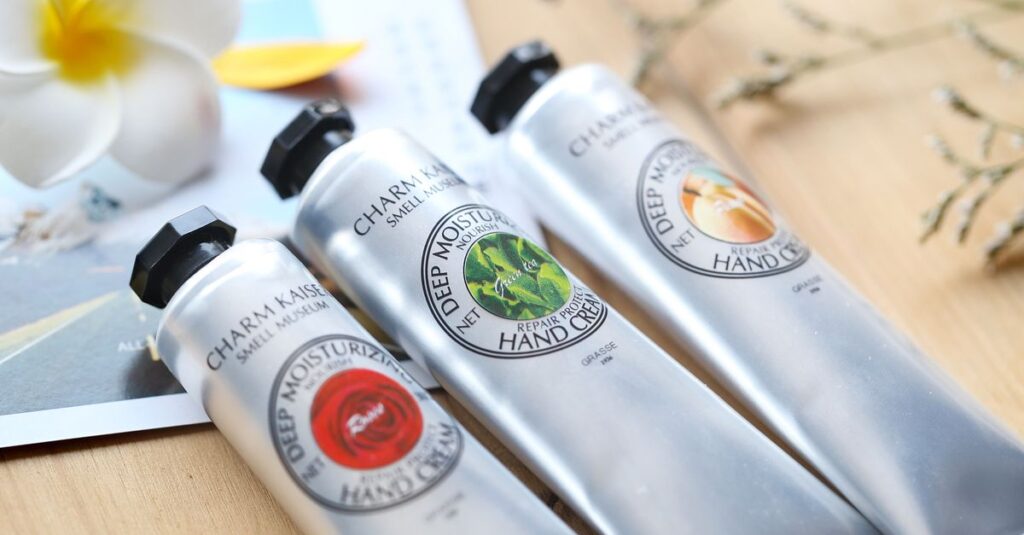 Close-up of hand cream tubes with a floral background, showcasing beauty and care products.