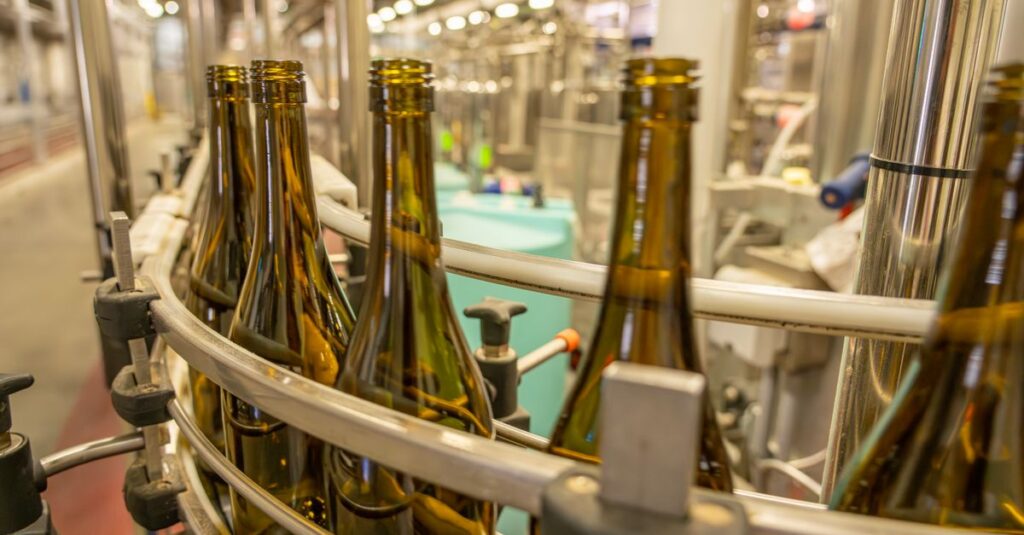 Close-up view of glass bottles on an industrial production line in a manufacturing facility.