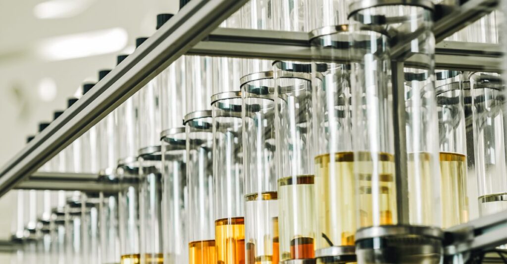 Close-up of automated bottle filling machinery in Dubai factory with colorful liquids.