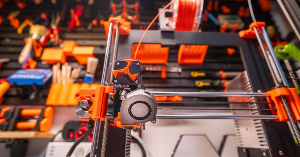 Detailed view of a 3D printer with filament and tools in a workshop setting.