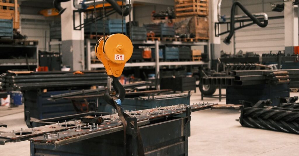 Close-up of a yellow industrial crane hook in a manufacturing workshop in Konya, Türkiye, showcasing metalwork.