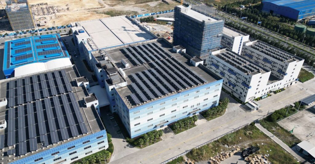 Industrial buildings with solar panels, aerial view showcasing renewable energy.
