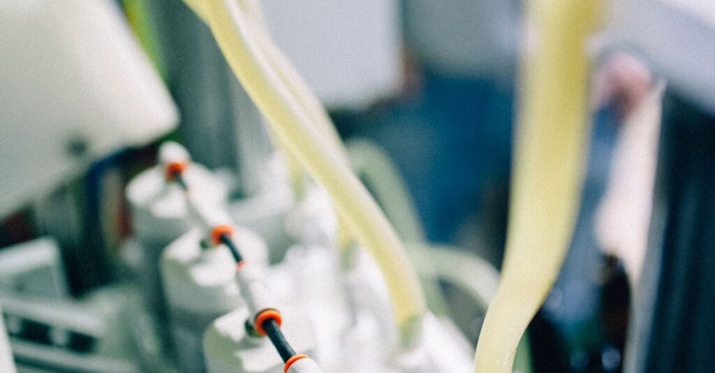 Detailed view of a bottling line in a high-tech brewery focusing on hoses and machinery.