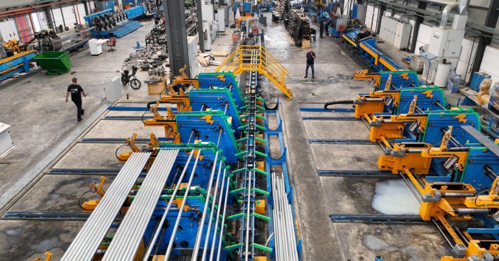 Aerial view of a large manufacturing plant interior with machinery and workers.