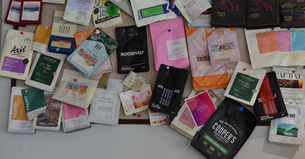 A vibrant collection of diverse coffee packaging pinned on a bulletin board, showcasing various brands.
