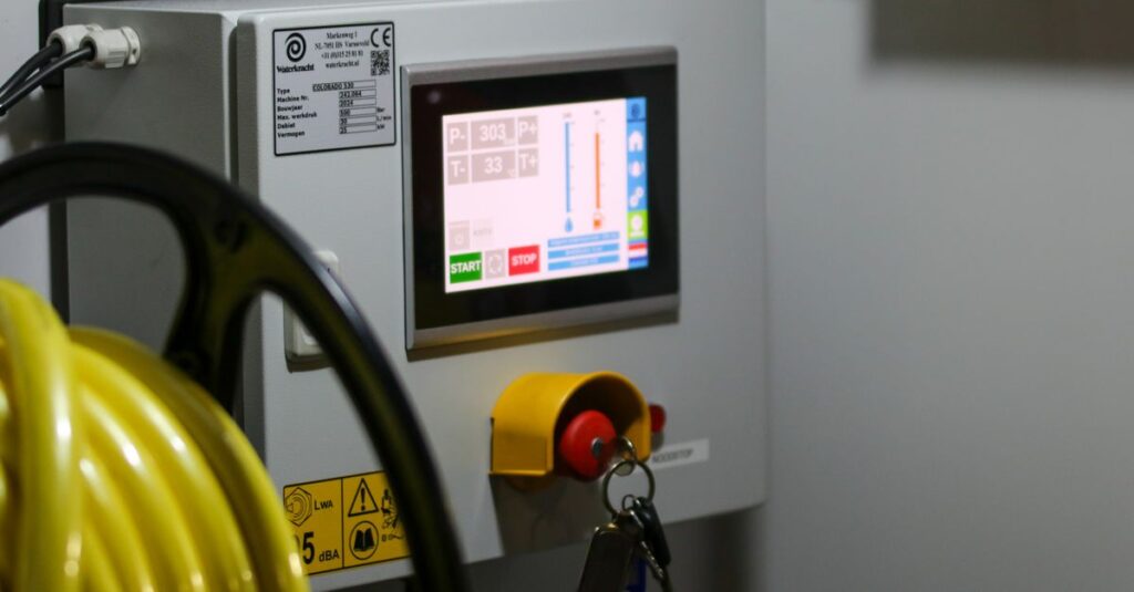 Close-up of an industrial control panel displaying safety features and a digital screen.