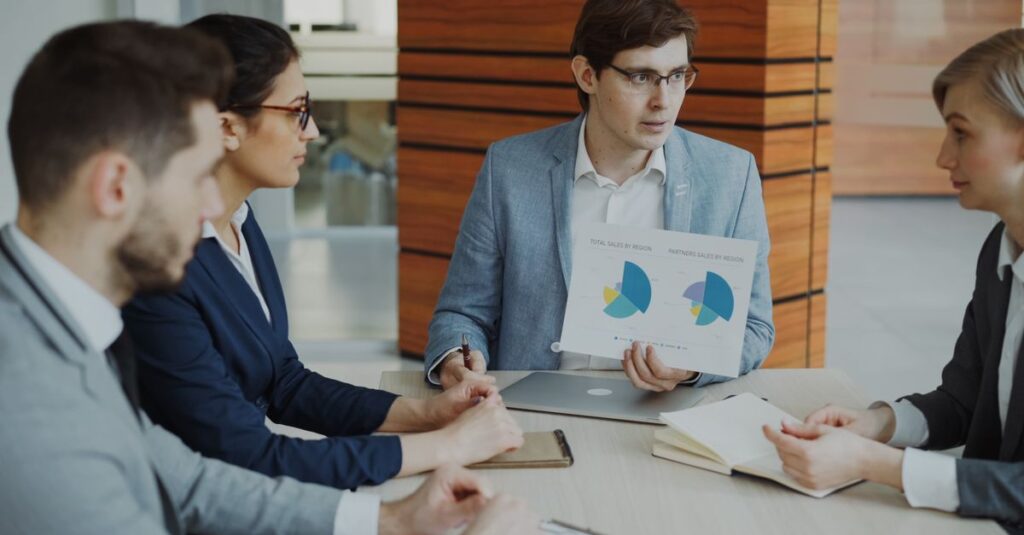 Group of professionals discussing charts during a business meeting.