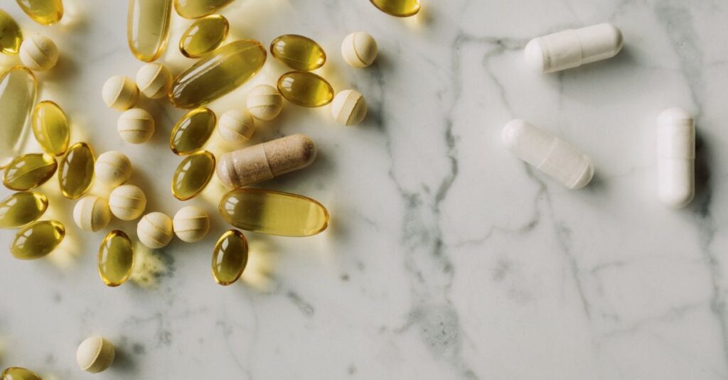 A variety of capsules and pills scattered on a marble surface, offering a modern healthcare concept.