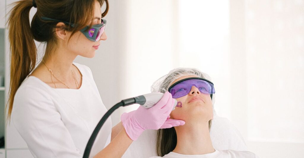 A cosmetologist performing laser treatment on a woman in a clinic setting.