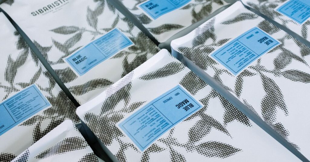 Close-up of branded coffee packages with artistic black and white leaf pattern.