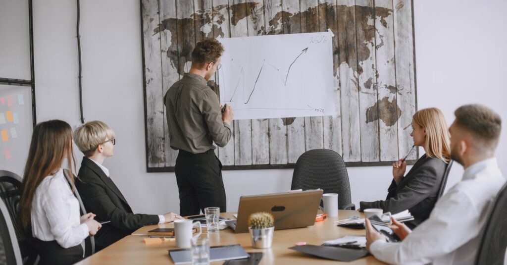 Group of business professionals discussing strategies with growth chart in conference room.
