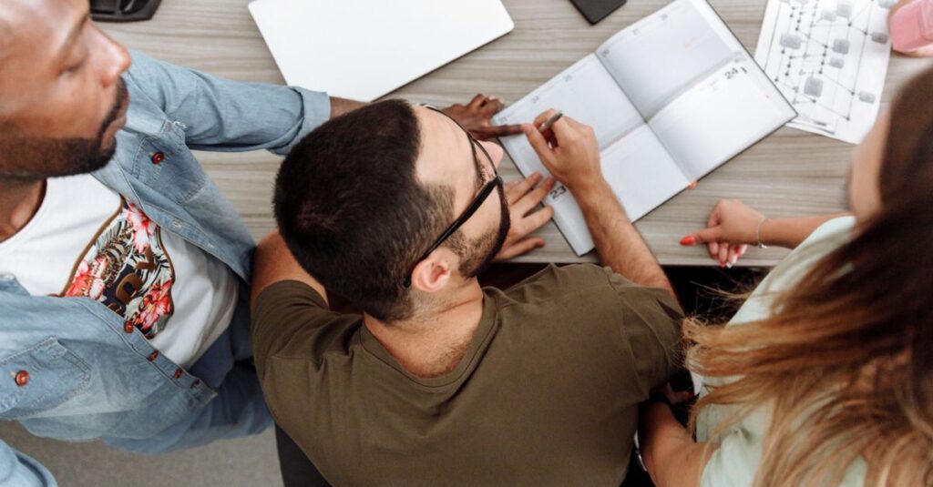 Overhead view of a diverse team collaborating around a desk in a modern office.