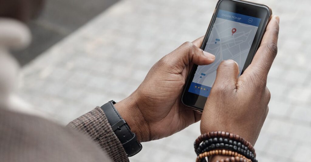 A man checking GPS navigation on a smartphone in a city street.
