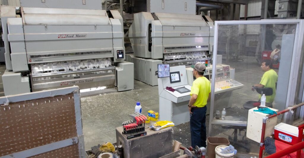 Workers operating machinery in a cotton gin factory in North Carolina