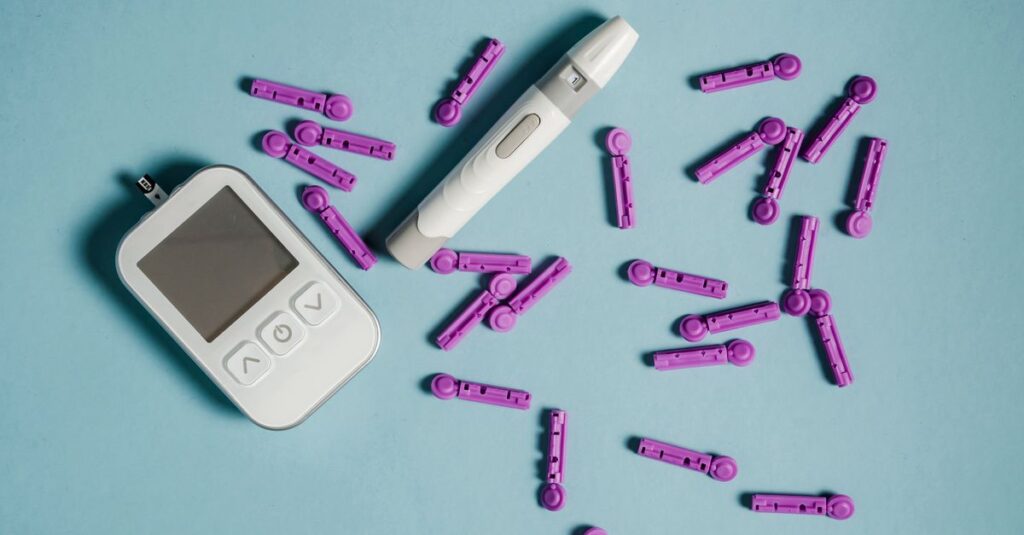 Top view of lancets scattered around blood glucose meter and lancing device on blue background