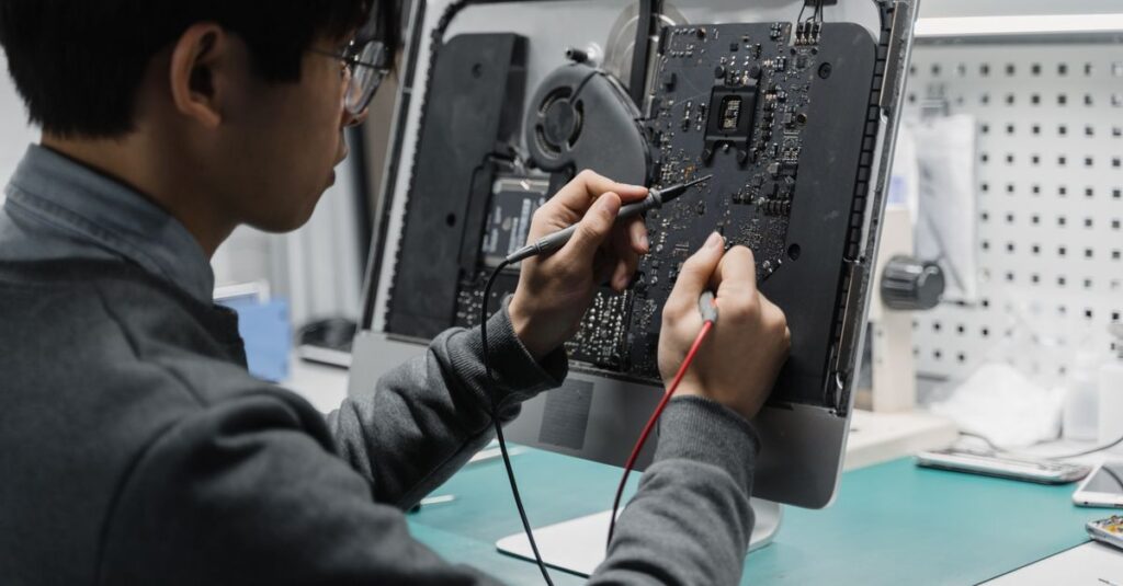 A technician works on a computer motherboard using tools at a workspace, focusing on electronics repair.
