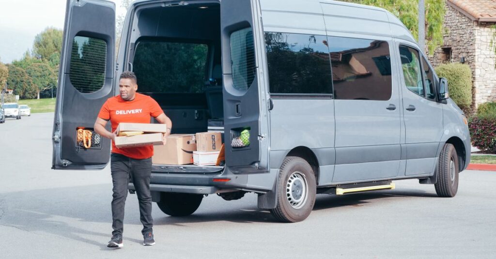 Courier in a delivery van distributing packages in a suburban setting.