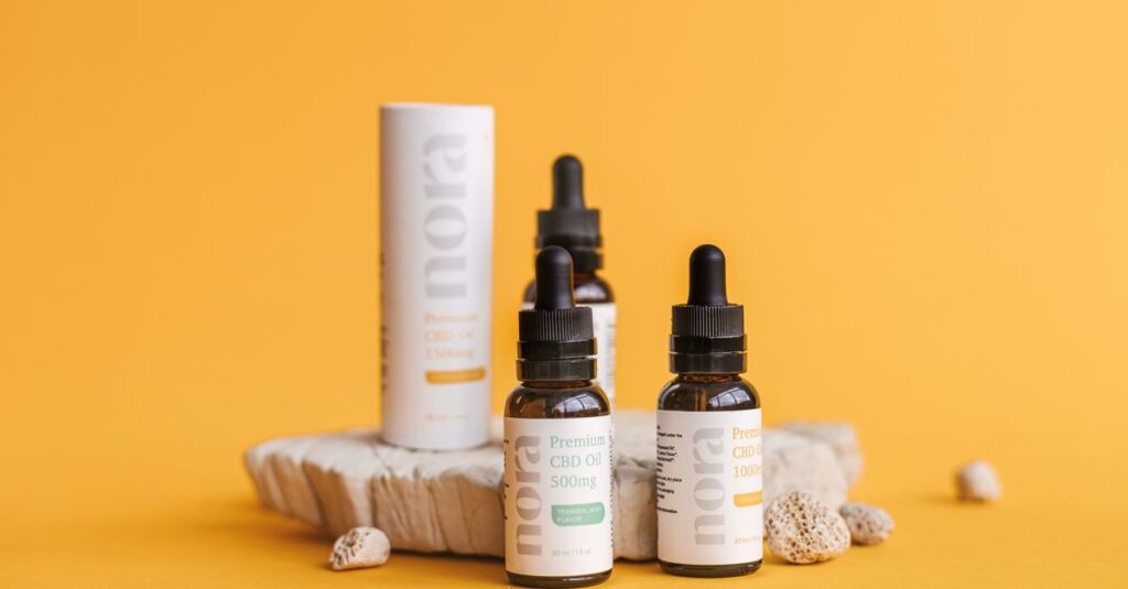 Stylish product shot of CBD oil bottles with packaging on a yellow background highlighting modern design.