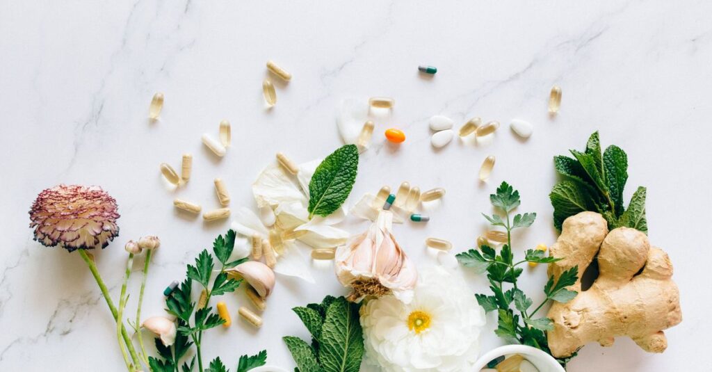 Natural herbs and pills arranged on a marble surface for a holistic healthcare theme.