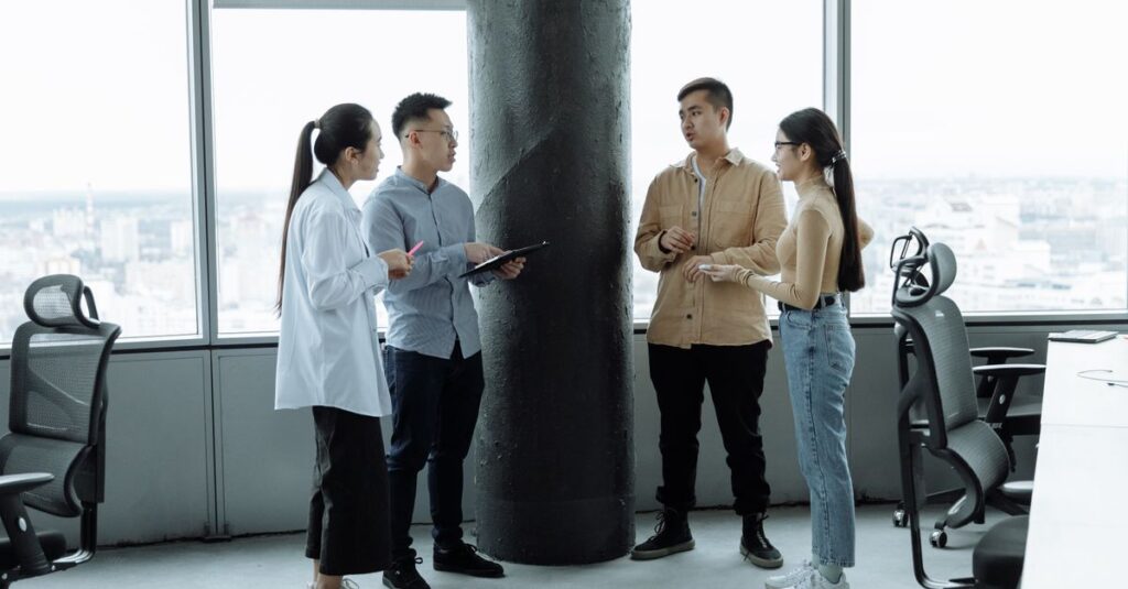 Diverse team discussing ideas in a modern office with city view, fostering collaboration.