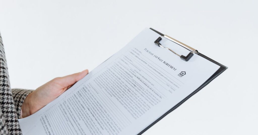 Person holding a filled contract on a clipboard with a pen against a white background.