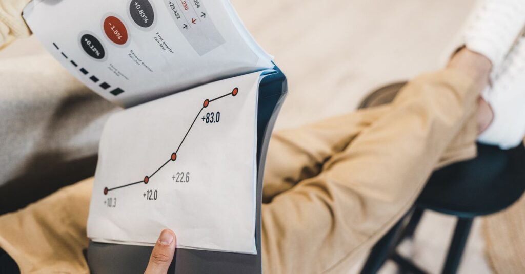 Close-up of a man reviewing business growth charts and statistics in an office setting.