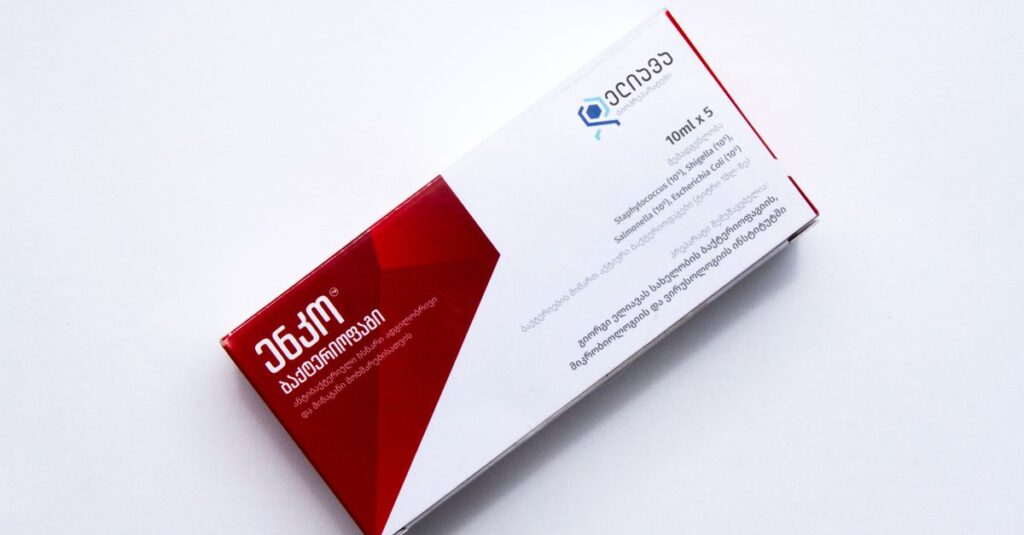 Close-up of a red and white medication box on a white background, showcasing retail packaging.