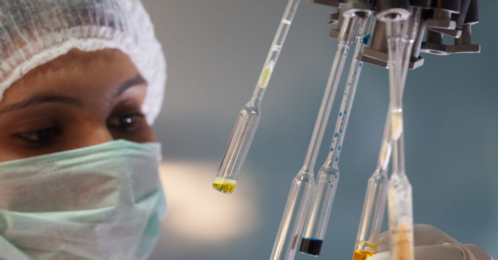 Woman scientist in lab handling test tubes with precision and focus.