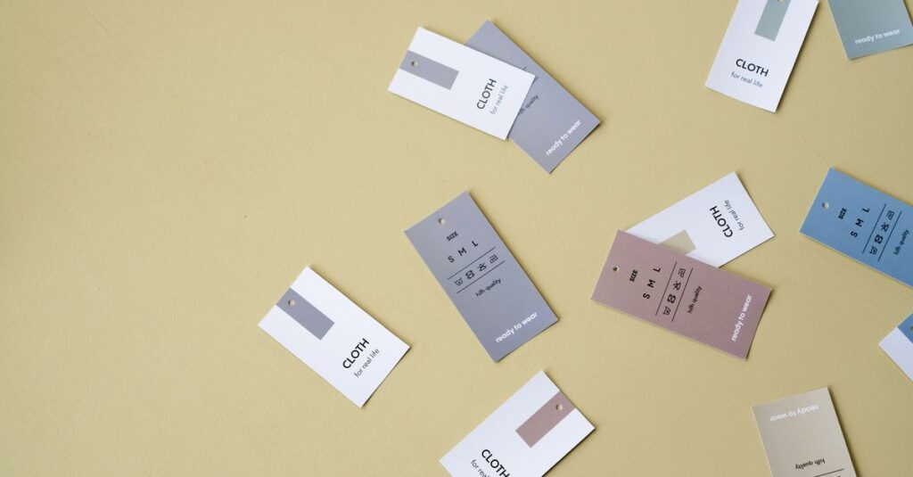 Floating clothing tags in various colors against a yellow backdrop with ample copy space.
